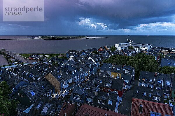 View from the upper land over the houses in the lower land to the Helgoland dune  Helgoland island  evening light  cloudy sky  North Sea  Pinneberg district  Schleswig-Holstein  Germany  Europe