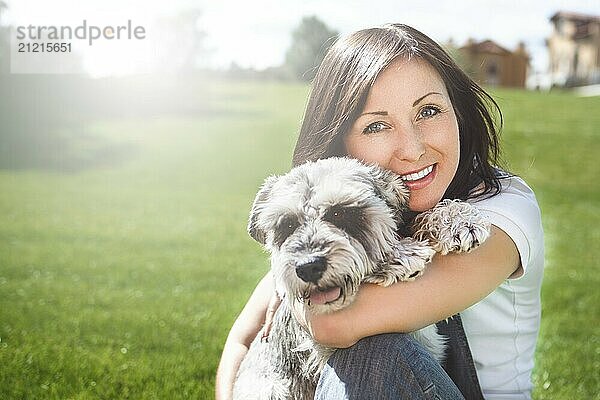 Portrait of a happy caucasian woman who hugs her beloved dog.The concept of love for animals. best friends. Dog breed Schnauzer. sunny day