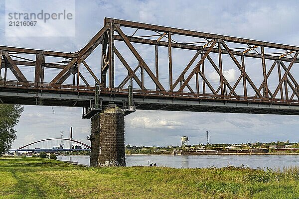 The railway bridge Duisburg-Hochfeld-Rheinhausen  over the Rhine  regional trains and many goods trains cross the Rhine here  from 1950  steel truss bridge  in the background the Bridge of Solidarity in DU-Rheinhausen  road bridge  Duisburg  North Rhine-Westphalia  Germany  Europe