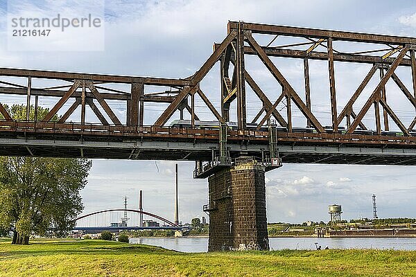 The railway bridge Duisburg-Hochfeld-Rheinhausen  over the Rhine  regional trains and many goods trains cross the Rhine here  from 1950  steel truss bridge  in the background the Bridge of Solidarity in DU-Rheinhausen  road bridge  Duisburg  North Rhine-Westphalia  Germany  Europe