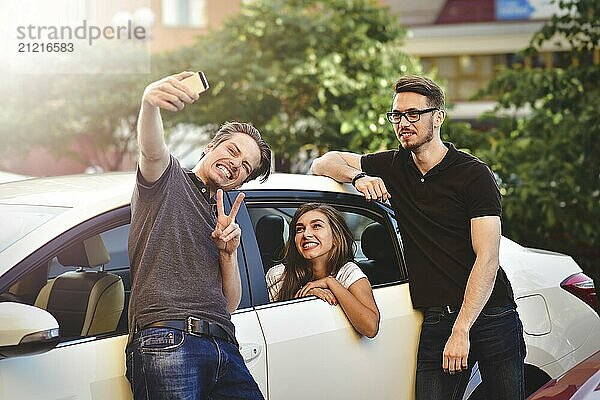 Three friends having fun taking a conversation near the car