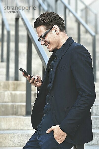 Happy caucasian businessman in glasses dressed at classic wear standing at the street