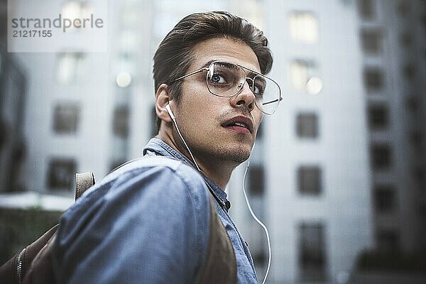 Portrait of handsome successful businessman walking on the street and thinking about startup project