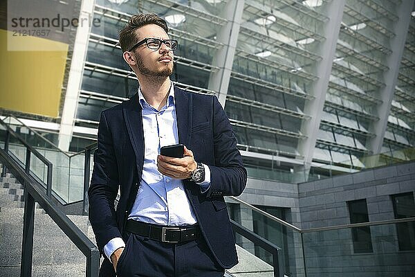 Handsome successful businessman in elegant suit outdoors walking on street in the city