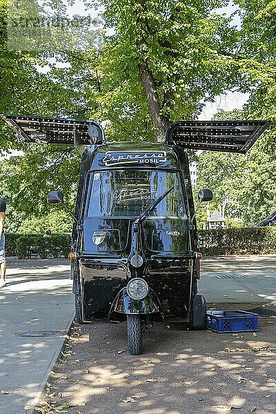 Frontalansicht eines mobilen Kaffeewagens unter Bäumen  Wien