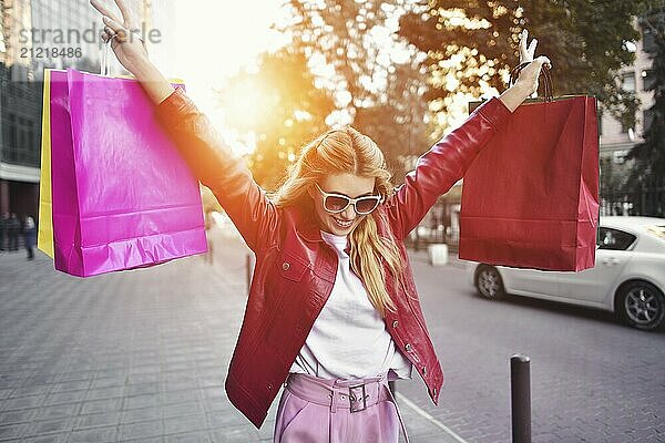 Shopping woman walking outside at street holding shopping bags. Shopper smiling happy walking the street after shopping