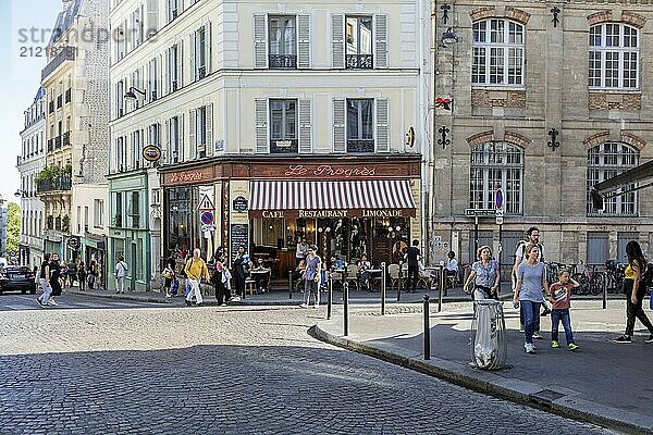 Menschen gehen an einem belebten Eckcafé in einer urbanen Umgebung vorbei  Paris