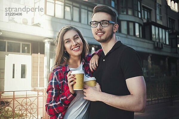 Awesome couple walking at street and drink a coffee