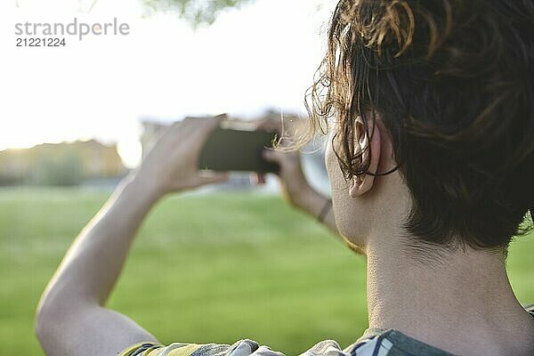 Close-up guy takes pictures of nature  beautiful views on his smartphone. summer mood