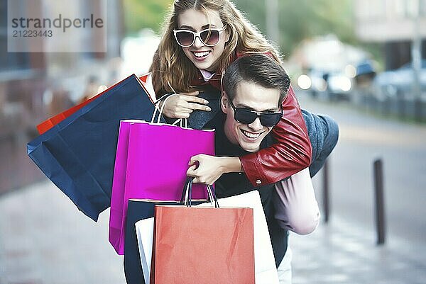 Happy couple shopping together and having fun. Boyfriend carrying his girlfriend on the piggyback