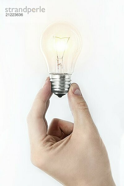 A man's hand holding a burning light bulb on a white background