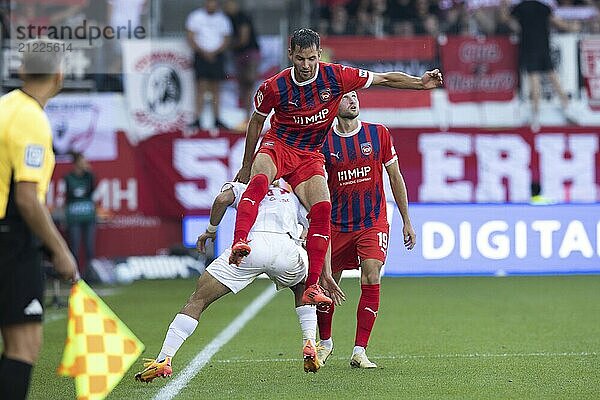 Football match  Marvin PIERINGER 1. FC Heidenheim literally sits on the back of Ritsu DOAN SC Freiburg  Jonas FÖHRENBACH 1. FC Heidenheim watches the direction of the ball with his eyes upwards  Voith-Arena football stadium  Heidenheim