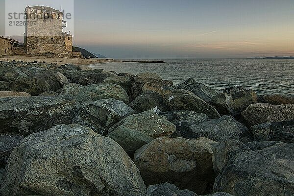 View over the sea into the sunset. Landscape taken with the historical landmark of the Byzantine tower of Prosphorion on the coast of Ouranoupoli  Thessaloniki  Central Macedonia  Greece  Europe