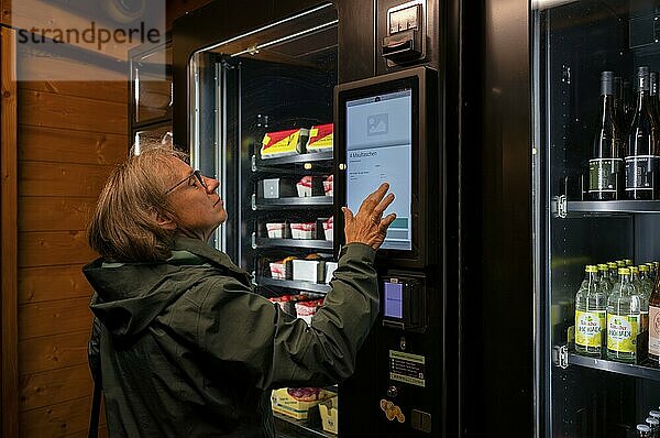 Elderly woman buying groceries at vending machine  display  food vending machine  farm shop  Stuttgart  Baden-Württemberg  Germany  Europe