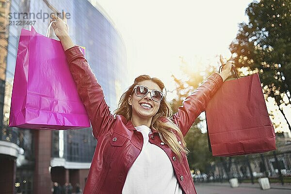 Shopping woman walking outside at street holding shopping bags. Shopper smiling happy walking the street after shopping