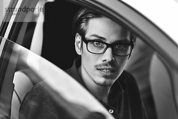 Enjoy the drive. Image of young handsome guy sitting in car