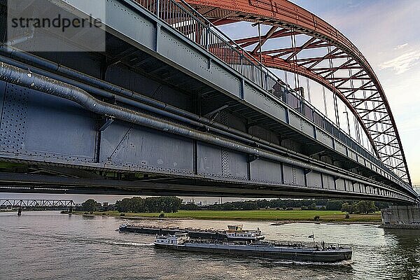 The Bridge of Solidarity  the longest tied-arch bridge in Germany  over the Rhine from Duisburg-Hochfeld to DU-Rheinhausen  the road bridge is dilapidated and has to be rebuilt  many thousands of lorries from the Logport port and cars use the bridge every day  new construction by 2040  cargo ships  behind the Duisburg-Hochfeld railway bridge  Duisburg  North Rhine-Westphalia  Germany  Europe