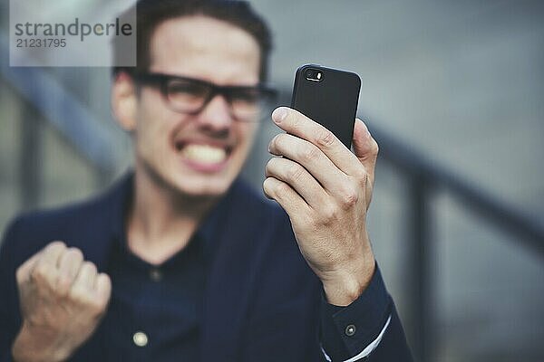 Happy caucasian businessman in glasses dressed at classic wear standing at the street