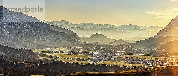 Malerische Alpenlandschaft bei Sonnenuntergang mit Nebel im Tal  sanften Lichtstrahlen und beeindruckendem Bergpanorama  Inntal