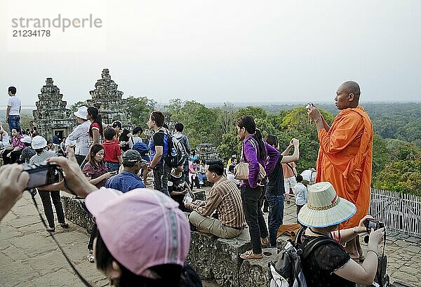 Buddhist monk and tourists in angkor wat cambodia