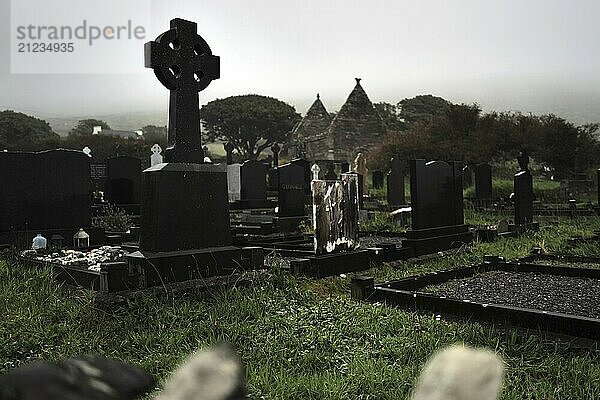 A Celtic cross and graveyard as seen from the road on a rainy day in the west of Ireland. Kilmalkedar  County Kerry  Ireland  Europe