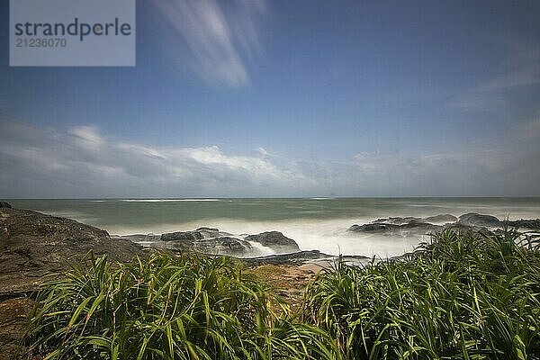 Strand  mit Lavafelsen und Vegetation  Blick auf das Meer am Abend bei Sonnenuntergang. Landschaft mit Wolken in Induruwa  Bentota Beach  Sri Lanka  Indien  Asien