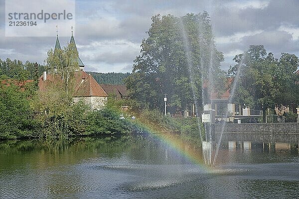 View from the Feuersee lake to the town church  rainbow  water feature  water fountain  Swabian-Franconian Forest nature park Park  Murrtal  Murr  Murrhardt  Baden-Württembergm  Germany  Europe