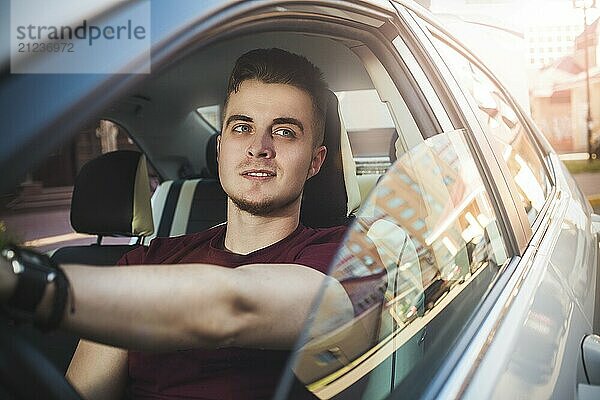 Enjoy the drive. Image of young handsome guy sitting in car