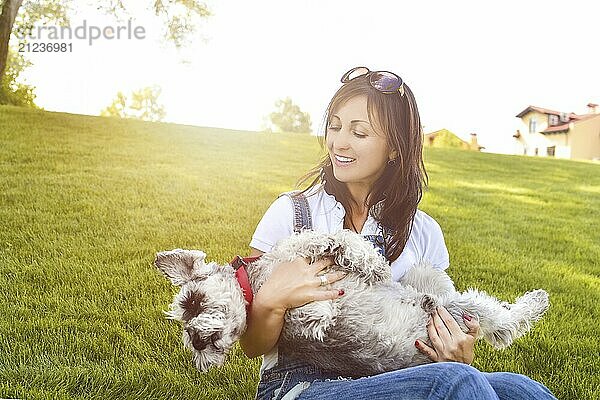 Portrait of a happy caucasian woman who hugs her beloved dog.The concept of love for animals. best friends. Dog breed Schnauzer. sunny day