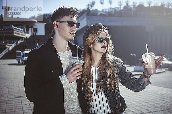 Cute couple having fun walking at the street and drink cocktails  good day