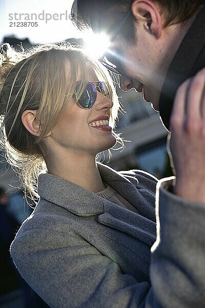 Happy playful couple in sunglasses in love dating joking and laughing in the street