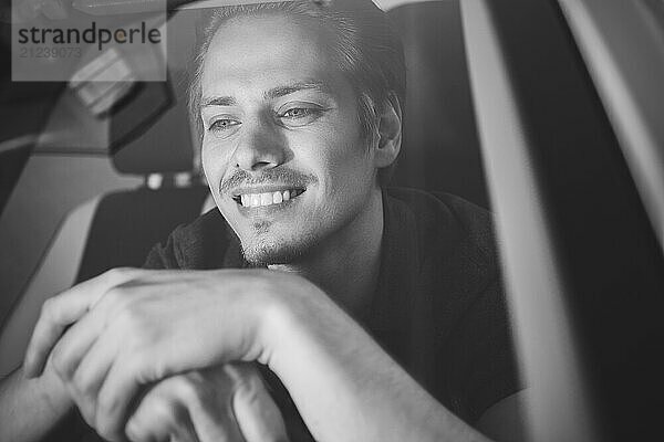 Enjoy the drive. Image of young handsome guy sitting in car