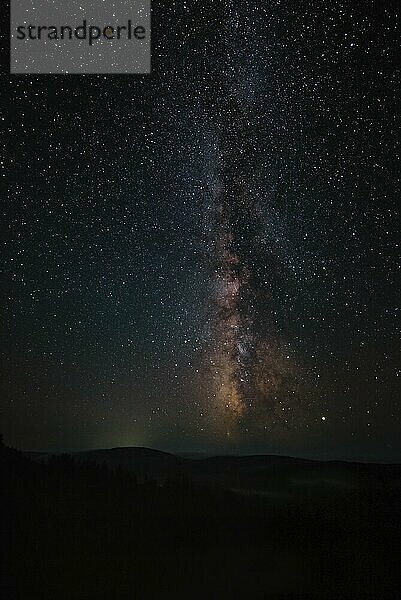 Milchstraße und rosa Licht in den Bergen. Nacht bunte Landschaft. Sternenhimmel mit Hügeln im Sommer. Schönes Universum. Space Hintergrund mit Galaxie. Reisen Hintergrund