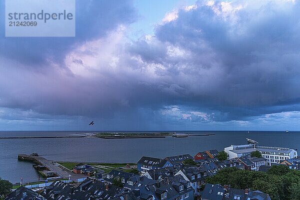 View from the upper land over the houses in the lower land to the Helgoland dune  Helgoland island  evening light  cloudy sky  North Sea  Pinneberg district  Schleswig-Holstein  Germany  Europe