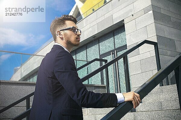 Handsome successful businessman in elegant suit outdoors walking on street in the city