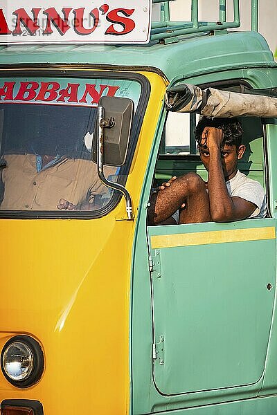 Young man in a yellow-green cargo rickshaw  Fort Cochin  Kochi  Kerala  South India  India  Asia