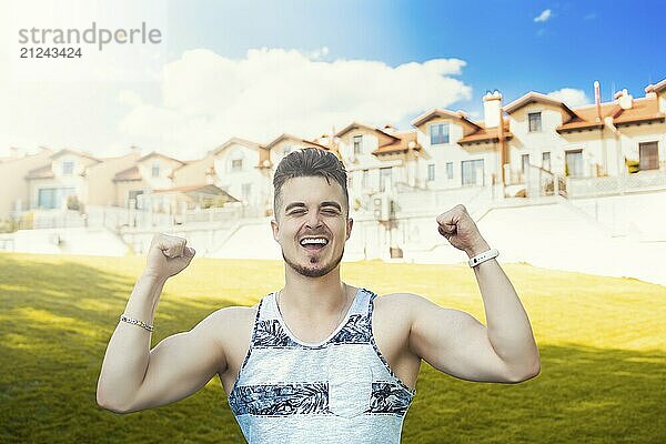 Expressive emotion. Attractive vacation. Happy young man got good news. beautiful cottages in the background