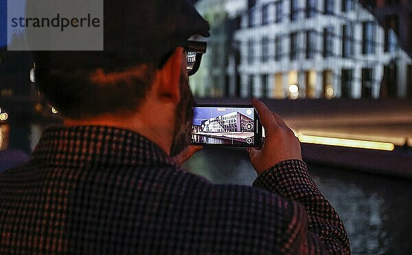 Ein Mann fotografiert mit einem Smartphone das Humboldt Forum während des Festival of Lights  Berlin  07.10.2024.  Berlin  Berlin  Deutschland  Europa