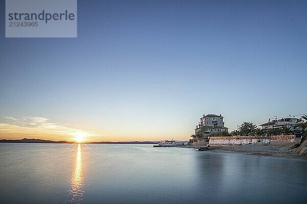 View over the sea into the sunset. Landscape taken with the historical landmark of the Byzantine tower of Prosphorion on the coast of Ouranoupoli  Thessaloniki  Central Macedonia  Greece  Europe