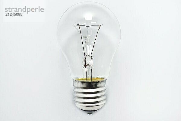 One incandescent bulb lying on white