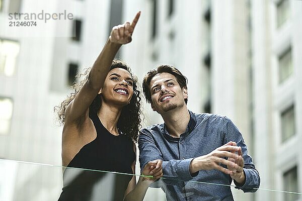 Happy international couple have a conversation in city. Mixed-race woman and caucasian man