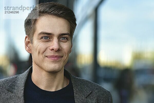 Trendy handsome happy man stay at street in gray coat and blue sweater