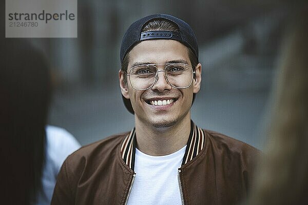 Portrait of a handsome young man standing against a crowded street background