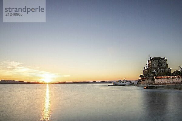 View over the sea into the sunset. Landscape taken with the historical landmark of the Byzantine tower of Prosphorion on the coast of Ouranoupoli  Thessaloniki  Central Macedonia  Greece  Europe