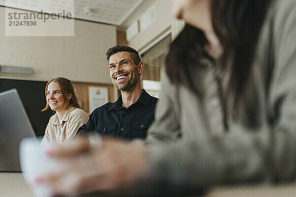 Happy male and female business professionals in meeting at office