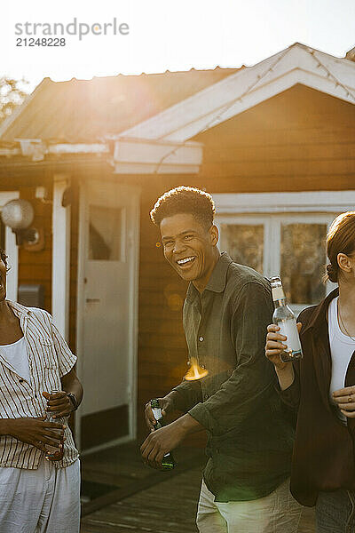 Portrait of happy young man dancing with friends in back yard at social party