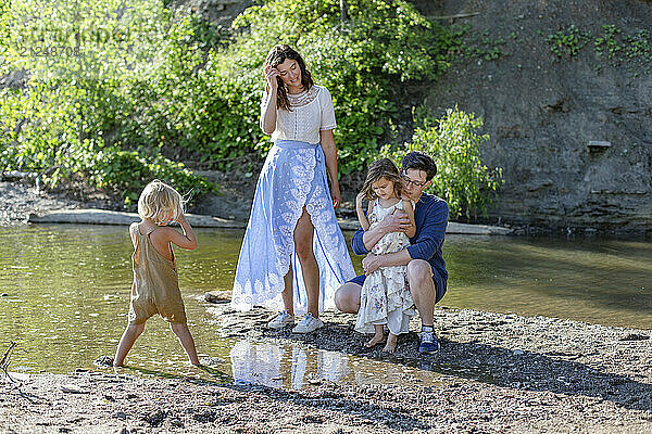 Family of four spending time together on a sunny day at the riverbank