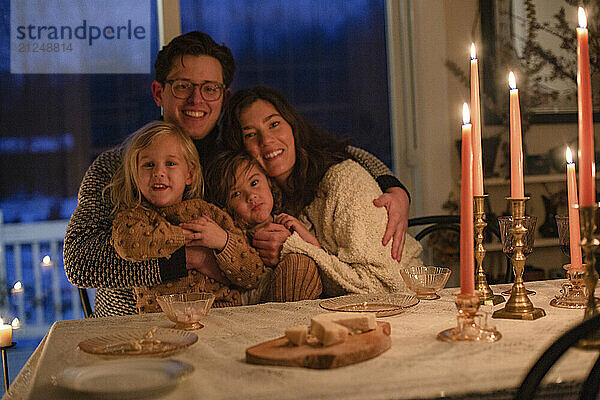 Family enjoying a warm  candlelit dinner at an elegantly set table during the evening.