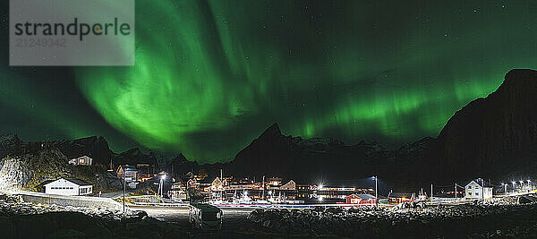 Night view of northern lights over fishing port in Lofoten Islands  Norway.