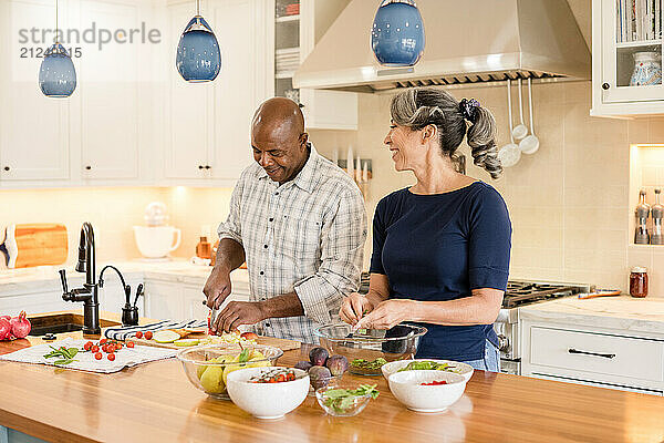 Couple smiling together in the kitchen while cooking